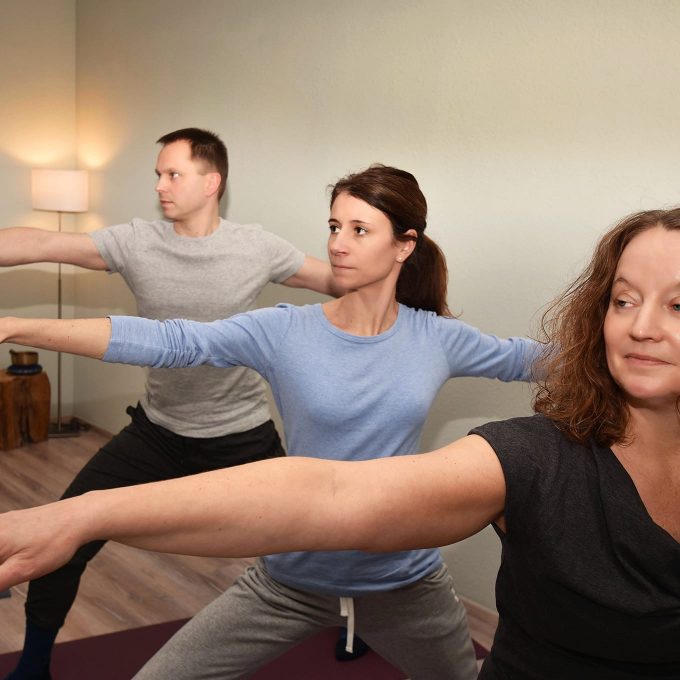 Yoga-Lehrerin und Yoga-Schüler trainieren zusammen